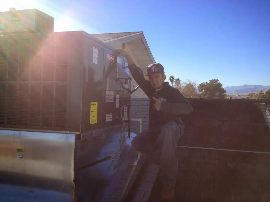 HVAC technician performing HVAC Inspection on a rooftop unit in Victoria